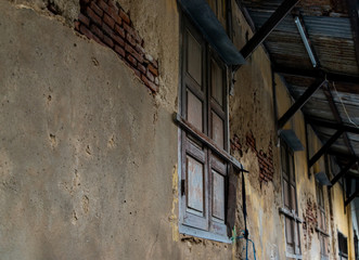 Fototapeta na wymiar Old wooden windows on the old wall. Traditional Architecture style, Selective focus.