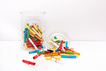 Obraz premium Small roll wish papers and a jar on white background. Wish jar. Wish concept. Dream, desire, wish, intention.