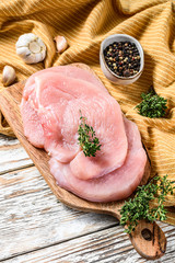 Fresh Turkey steaks with thyme and pepper on cutting board. Raw organic poultry meat. white background. Top view - obrazy, fototapety, plakaty