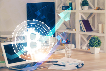 Multi exposure of blockchain theme hologram and table with computer background. Concept of bitcoin crypto currency.