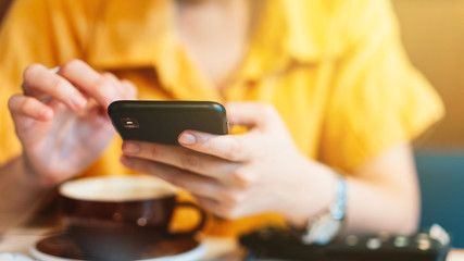 Close-up woman hands using mobile phone to review ordered food on her social media in cafe. Enjoy modern communication lifestyle.