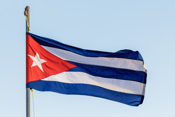 Flag of cuba waving with flagpole and blue sky
