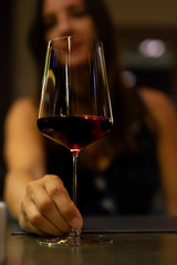 woman holding a glass of red wine on a romantic dinner