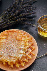 waffles in powdered sugar on a dark background, close-up