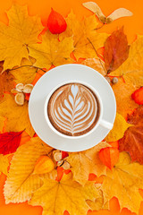 Coffee latte cup in dry autumn leaves wreath frame