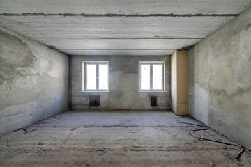Fototapeta na wymiar Empty living room in a country house without repair. Unfinished room with concrete walls and ceiling