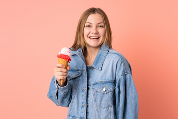 Teenager Ukrainian girl with a cornet ice cream isolated on pink background with surprise and shocked facial expression