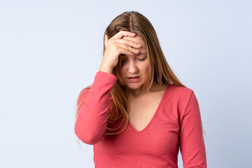 Teenager Ukrainian girl isolated on blue background with headache