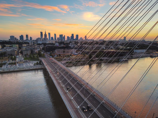 Fototapeta na wymiar Capital cityscape and a suspension bridge over a large river. Drone, aerial view