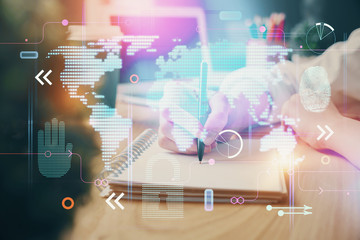 Double exposure of hands making notes with world map hologram and data theme icons. Concept of global computer data.