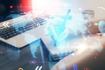 Double exposure of hands making notes with world map hologram and data theme icons. Concept of global computer data.