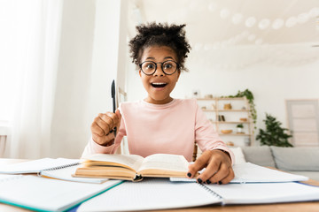 Excited Teen Girl Having Eureka Moment Doing Homework At Home