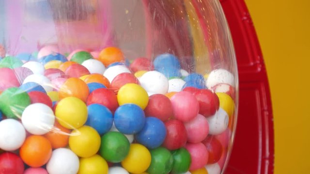 Colorful gumballs in classic vending machine, USA. Multi colored buble gums, coin operated retro dispenser. Chewing gum candies as symbol of childhood and summertime. Mixed sweets in vintage automate.