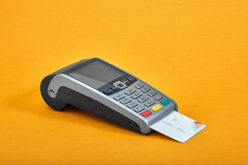 Payment by credit card. Terminal on yellow background copy space