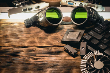Old computer chip and green glass protective glasses on the table.