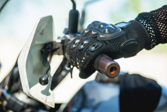 Motor biker hand on a motorcycle steering wheel close up.