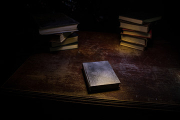 Imagine a picture book of an ancient book opened on a wooden table with a sparkling golden background. With magical power. magic. lightning around a glowing glowing book In the room of darkness