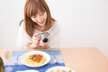 Obraz na płótnie Canvas 料理の写真を撮る女性