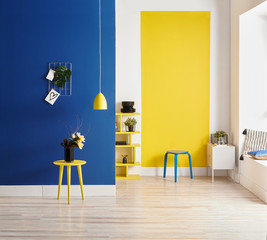 Yellow and blue wall background, interior style, round wood, frame and lamp.