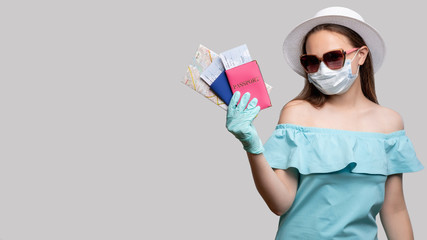 Quarantine prevention. Stay safe. Tourist woman ready for traveling. Isolated on gray copy space. COVID-19 pandemic protection. Summer vacation