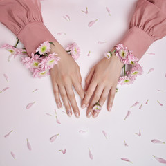 Obraz na płótnie Canvas Beauty hands woman with pink flowers are on the table. Natural cosmetic for hand skin care. Perfect nails