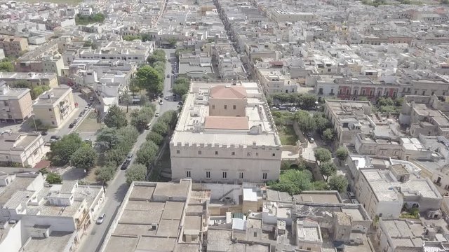 FRANCAVILLA FONTANA, ITALY - SEPTEMBER 07, 2018: Aerial view of Castello Imperiali (castle, fortress) in Brindisi province Puglia Italy. Rooftops, cityscape, cars go on streets. Summer
