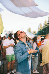 Hip man standing out for the crowd and dancing in the festival. Happy enjoying 