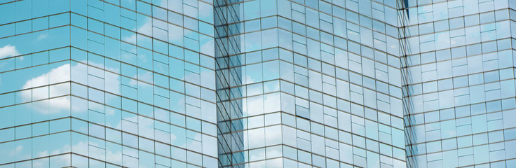 Cloud reflected in windows of modern office building.