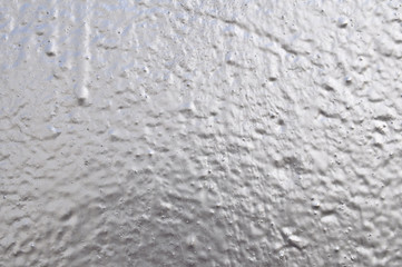 Concrete wall background with applied silver paint.