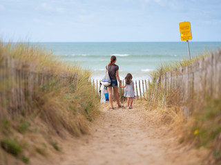 une mère et sa fille face à la mer en vacances