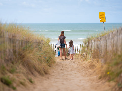 une m&egrave;re et sa fille face &agrave; la mer en vacances