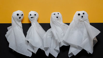 Homemade Halloween ghosts on a black and yellow background.