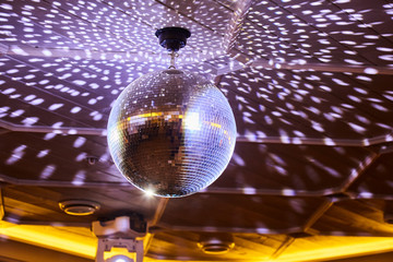 The disco ball reflects white light in a dark room. The concept of a disco, a party, a spinning...