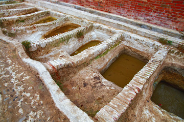 Different old stone vats with dye for leather at Tannery of Tetouan Medina. Northern Morocco.