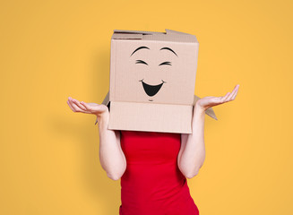 Person with cardboard box on its head and a smiling face stretching its hands out inquiringly on...