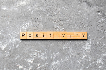 positivity word written on wood block. positivity text on cement table for your desing, concept