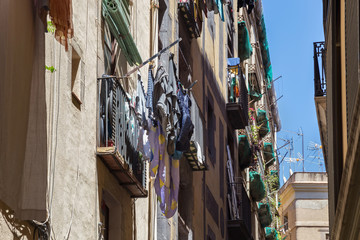 Fototapeta na wymiar Traditional drying clothes of the local people in the historic famous Gothic quarter of Barcelona in sunny day. Spain.
