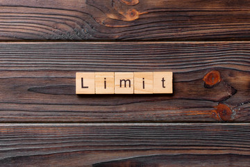 limit word written on wood block. limit text on table, concept
