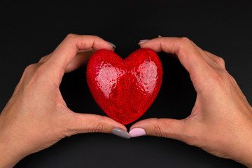 Female hands giving red heart