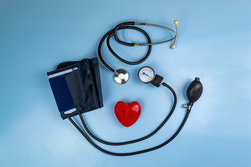 Red heart and stethoscope on a blue background. Medical care concept and copy space.