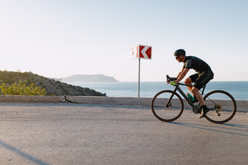Cycling sport athlete man riding on coastal road