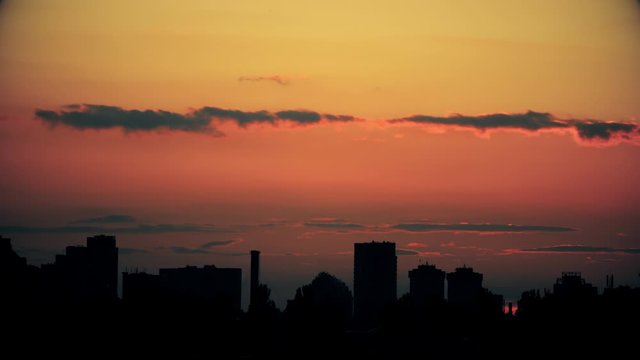 Dramatic colorful red fiery sunset timelapse sky landscape with line row of city buildings silhouette . Natural beautiful cityscape dawn background wallpaper. Metropolis rise twilight time