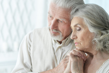 Portrait of sad senior couple posing at home