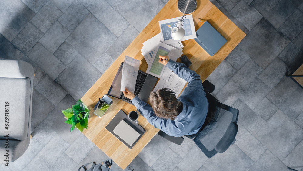 Poster businessman sitting at his desk in the office uses laptop computer, working with company strategy do