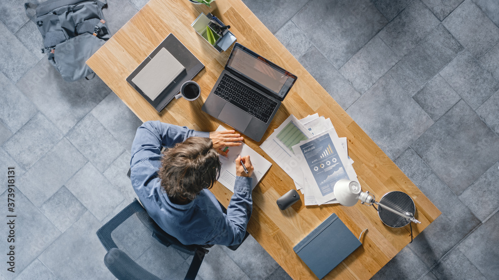 Poster businessman sitting at his desk in the office uses laptop computer, working with company strategy do
