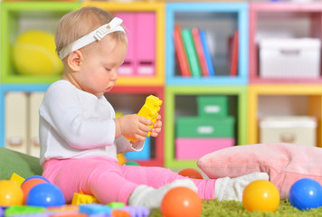 Portrait of little child playing with colorful toys