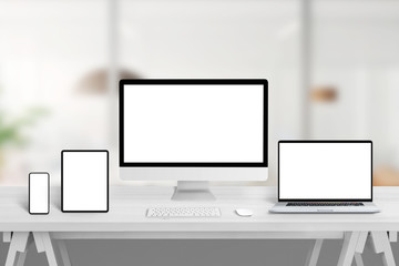 Computer display, laptop, tablet and smart phone on office desk with isolated display for web site,...