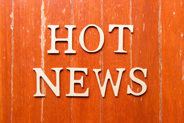 Alphabet letter in word hot news on old red color wood plate background