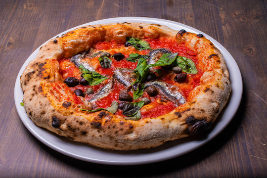 Pizza marinara napoletana con acciughe, olive nere e basilico