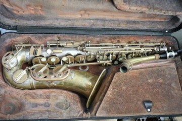 old Saxophone instrument on a wooden background